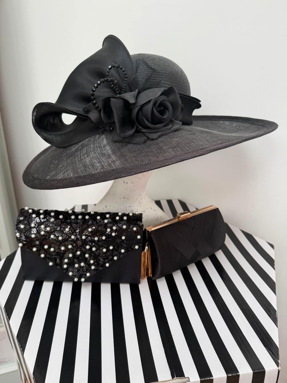 Black straw wide-brim hat with an organza rose and jet bead swirls, with two black occasion clutches