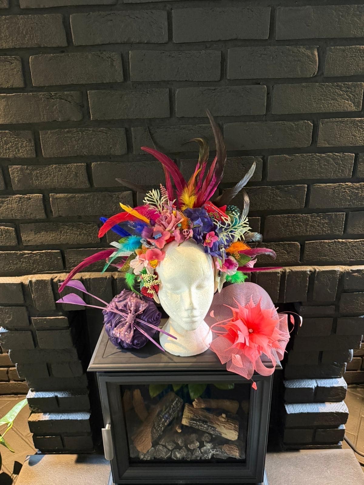 Multicoloured statement feather and flower headdress on a mannequin head