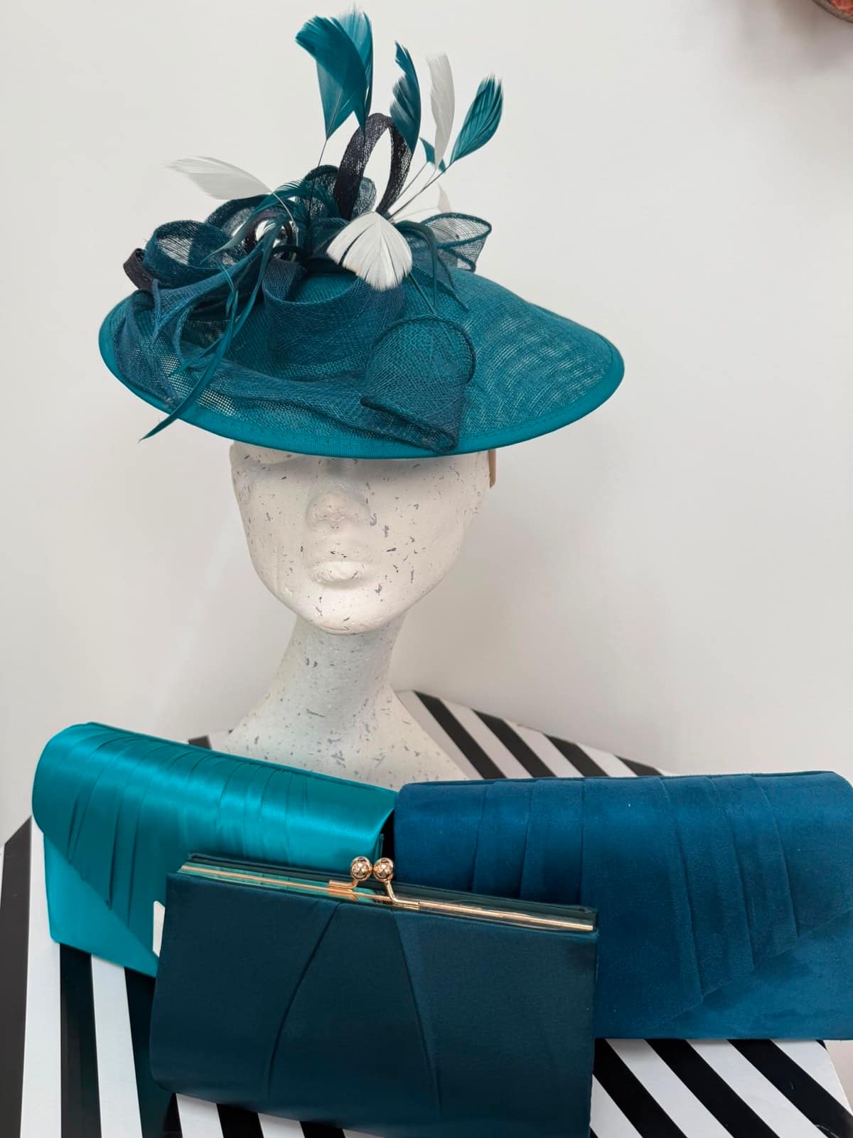 Teal wide-brim hatinator trimmed with navy and white feathers, with a trio of teal clutches